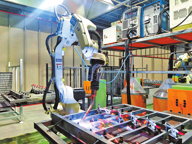 图②河南永强户外休闲企业车间内，机械手臂在进行激光切割作业。王耀成 摄