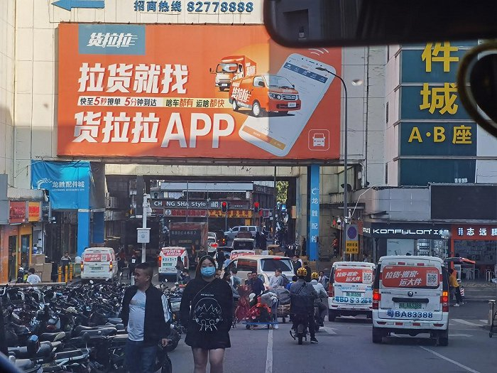 华强北随时可见贴有“货拉拉”等平台车贴的车辆。图片来源：陆柯言/摄