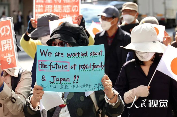 图为日本东京市民举着横幅和旗帜走上街头，反对真子公主与小室圭结婚。