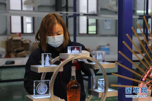 重庆六匠文化创意有限公司的工作人员在擦拭文创工艺品。新华网 韩梦霖 摄