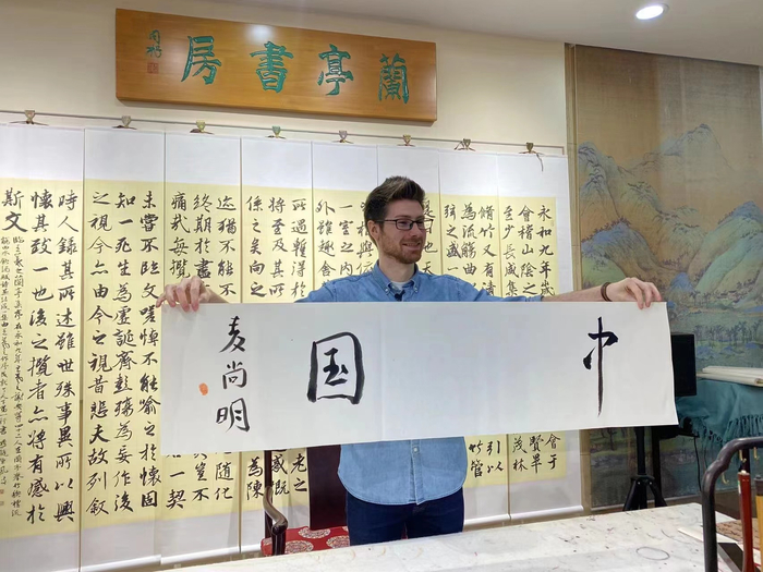 ▲2021年11月6日，在北京市天佑兰亭书法文化博物馆，Brian和老师一起写书法。受访者供图