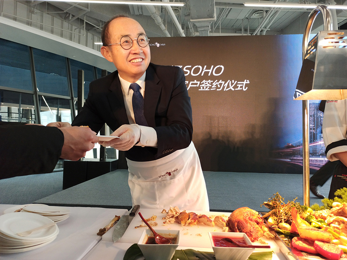 2019年11月28日，北京，丽泽SOHO首批客户入住签约现场，潘石屹为大家亲手切火鸡。图自视觉中国