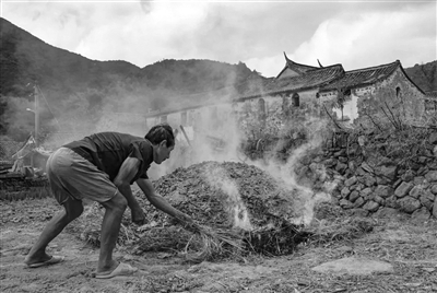     敬胜堂，堂外农民在烧麦秆。