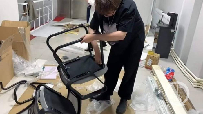 ▲2021年4月，郑前的房产中介公司开张，郑前自己动手组装办公桌。图片来源/受访者供图