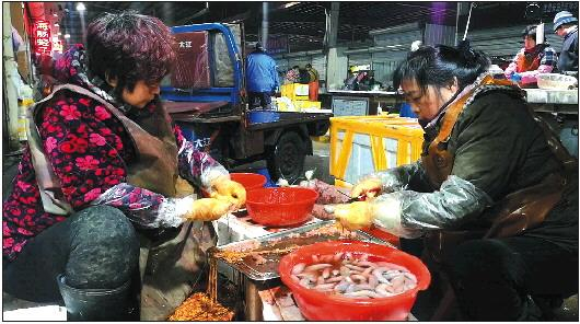 凌晨5点，烟台九田市场内，商家正在忙着处理、包装海肠。