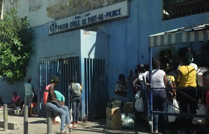 关押疑犯的太子港海地国家监狱门外，疑犯亲属排队为他们带去食物&nbsp; 图源/CNN