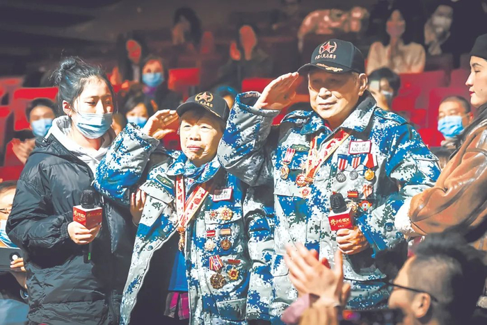 图为志愿军老战士王新善（右，90岁）、庄瑾（左，86岁）在电影首映式现场。观影结束后，两位老战士深情敬礼。（图片来源：央视网）