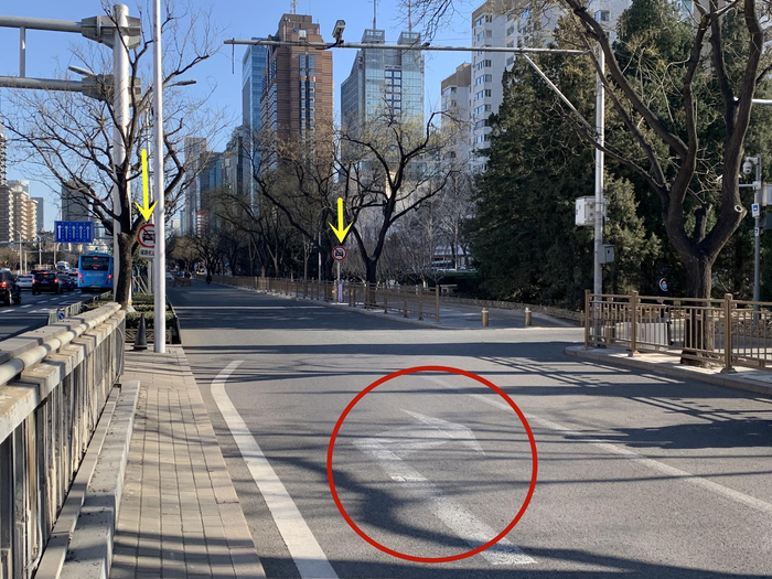 ▲右转路口附近指示，黄色箭头所指为机动车禁行标志，红圈处为路面右拐指示。新京报记者 李睿阳 摄