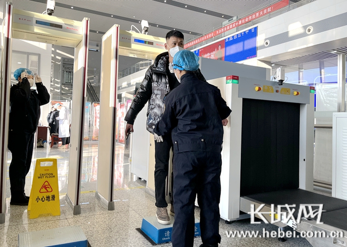 平泉北站工作人员防护在岗，为进站旅客进行安检。通讯员 杨新潮 摄