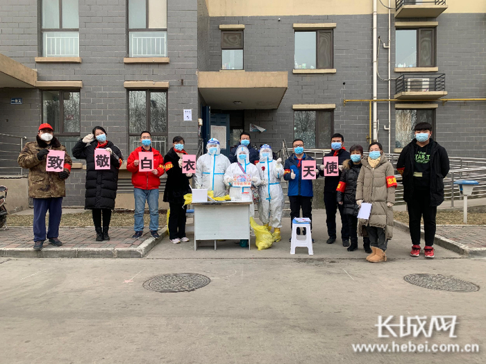 张海亮（右五）参与石家庄东方家园社区的志愿服务，图为该社区的“红领巾志愿队”与医护人员合影。