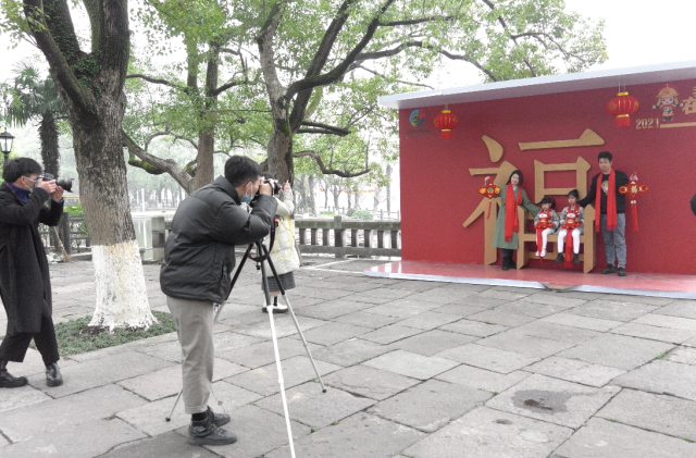 图为宁职院“艺源”公益服务站的学生们在给留在宁波过年的家庭拍摄全家福 照片由学校提供