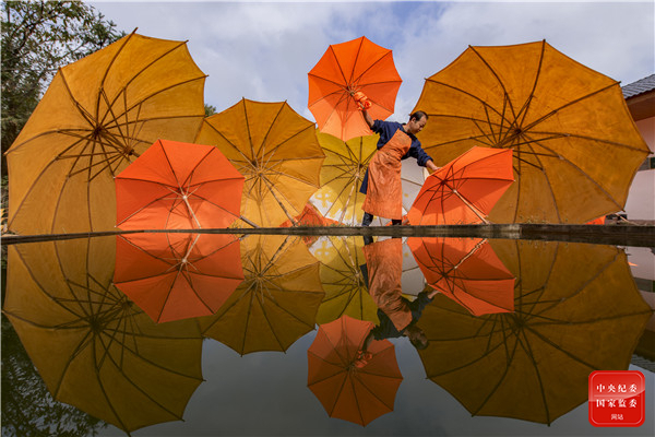 安徽省宣城市泾县油纸伞厂的匠人用传承的精湛纯手工手艺用心打磨每一把雨伞。精巧的伞骨、鲜艳的伞盖、生动的剪影，与工匠们在阳光下一起谱写非遗文化传承的新篇章。（安徽省宣城市宣州区纪委监委供 黄利宏 摄）