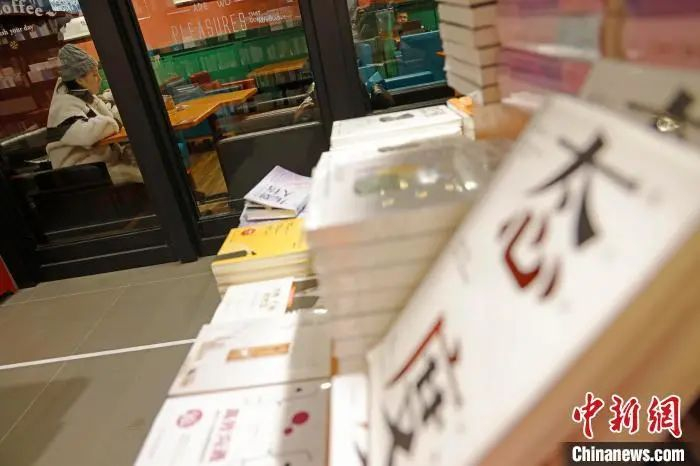 资料图：市民在书店边喝咖啡边看书。殷立勤 摄