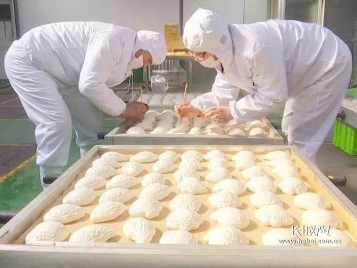 帝鉴食品有限公司面花生产加工间里，工人正在制作面花。通讯员 供图