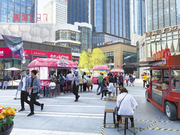 唐道·637内，市民享受街边美食。（陈曦 摄）