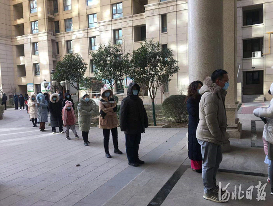石家庄市桥西区启锐园小区，居民在物业工作人员、志愿者等引导下，按楼号分批排队做核酸检测。河北日报记者王峻峰摄