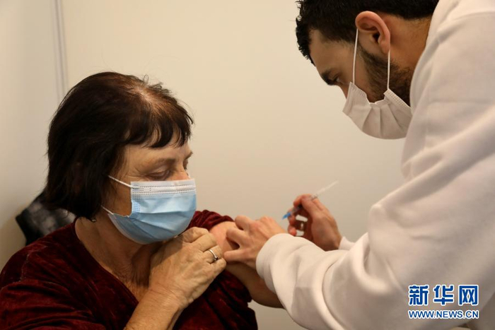 2020年12月31日，在以色列特拉维夫，一名女子接种疫苗。 新华社 图