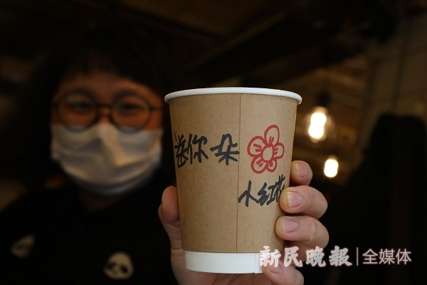 图说：为外卖顾客的纸杯上暖心写上独特的文字