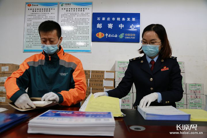 石家庄市税务发票邮寄中心共产党员寇文辉（右）保持着工作“零失误”纪录。 刘军 摄