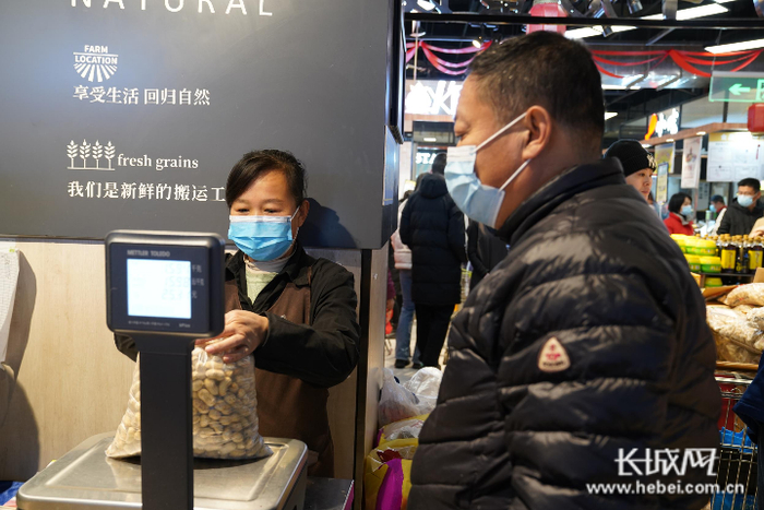 家乐园超市天一广场的工作人员正在为顾客挑选的商品称重。记者 郭硕 摄