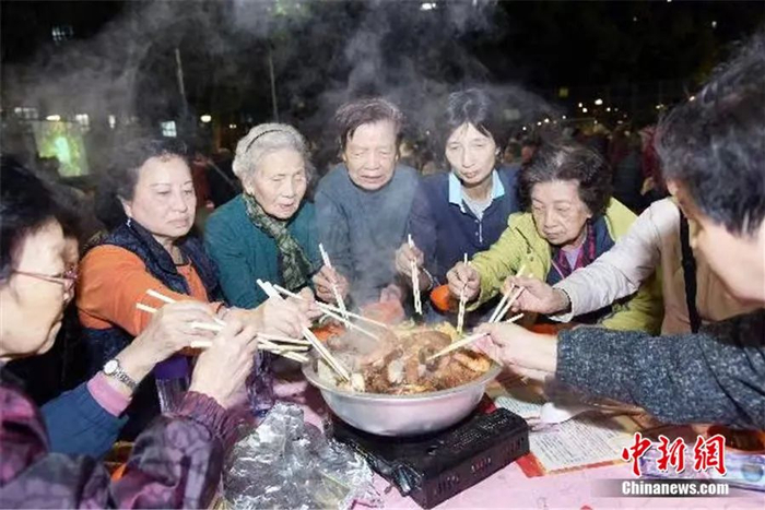 资料图：2018年12月18日，香港市民在品尝盆菜，充满气氛。中新社记者 李志华 摄