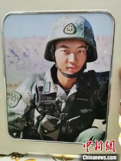 王焯冉身穿作战服与战友的一张合影，妈妈感觉儿子特别帅，特意放大镶嵌相框摆在家里。　王登峰　摄