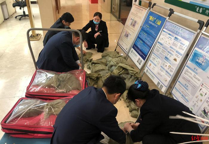 ▲工作人员将硬币临时封包