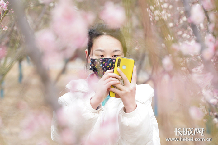 田文倩在园博园花丛中自拍留念。 长城网 记者 郭硕 摄