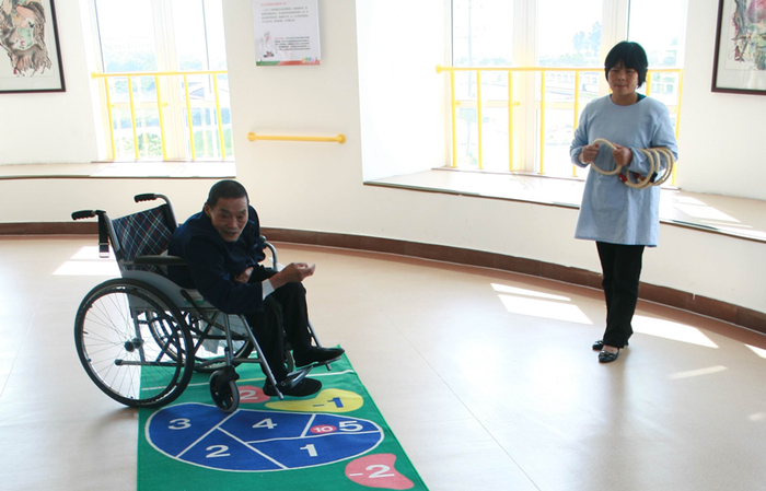 在玩玩具的过程中，老年人通过亲自动手，可以益智健脑和延缓衰老，还可以增加运动，促进疾病康复，改善身体的机能和状况。图为一位坐在轮椅上的老人在玩套圈游戏进行康复训练。CNSPHOTO提供