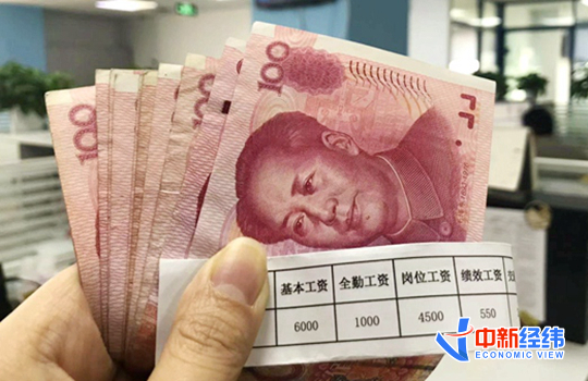 资料图：人民币和工资条。中新经纬熊家丽摄