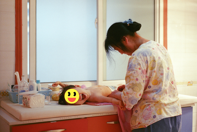 护理阿姨在为儿童更换纸尿裤。受访者供图