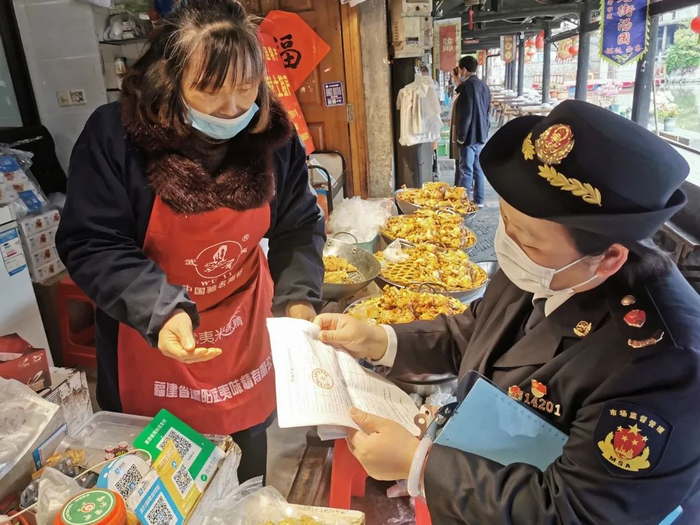 市场监管工作人员走访商户了解情况。