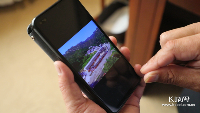 全国人大代表陈春芳向记者展示手机相册。