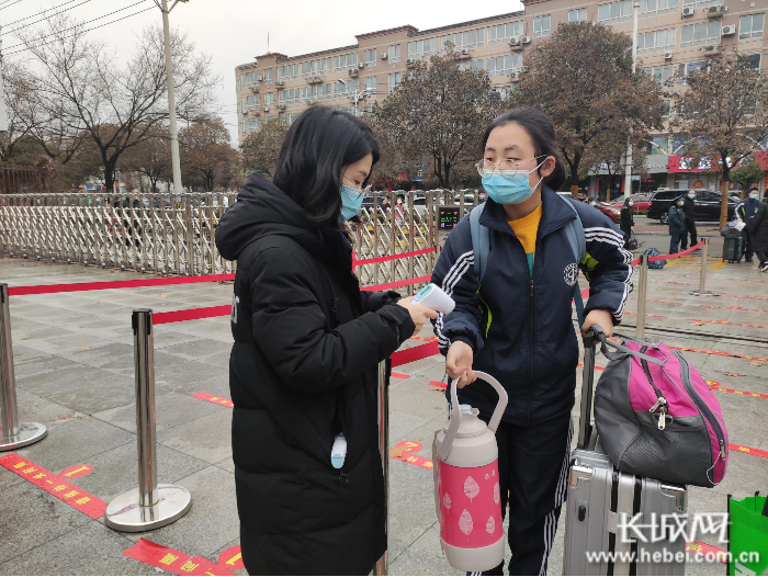 邢台市第一中学老师正在为入校学生测量体温。 长城网记者 齐彦红 摄