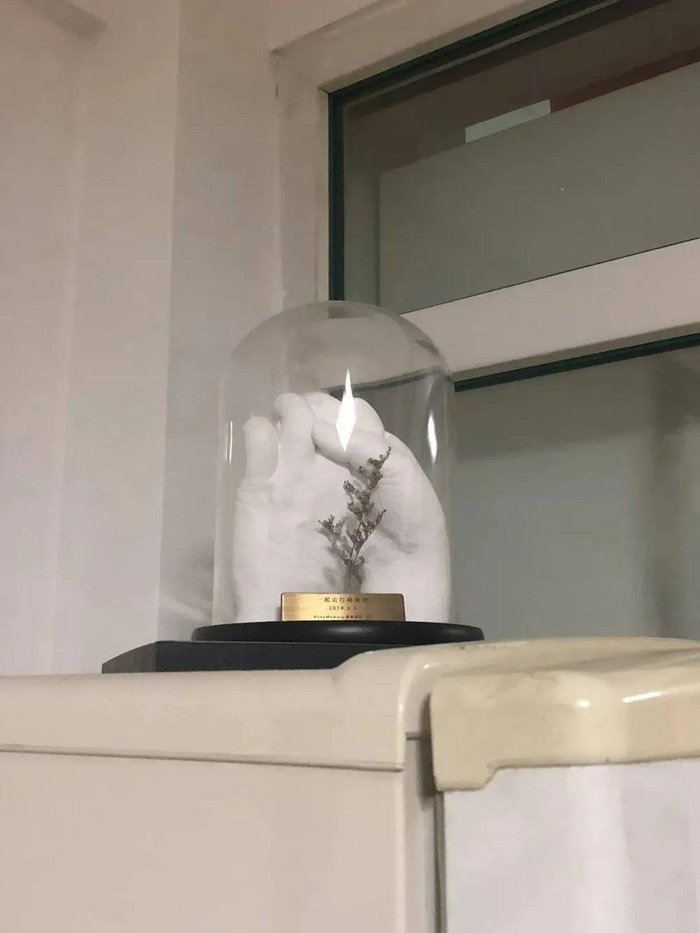 图| 老人将紧握双手的复刻雕塑摆在家里的冰箱上