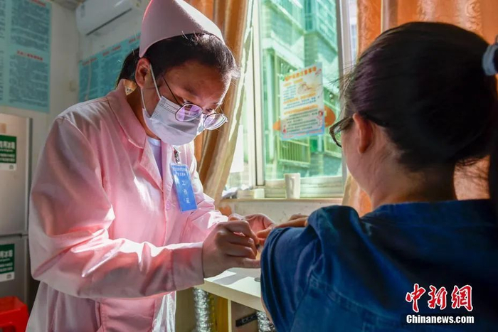 资料图：海口市凤翔街道下坎社区卫生服务站的工作人员为市民接种新冠疫苗。中新社记者 骆云飞 摄