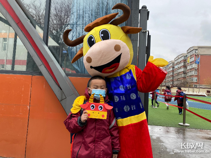 神兴小学教育集团雅清分校，身穿牛年卡通玩偶服的老师在学校欢迎师生回家，成为大家争相合影的对象。神兴小学教育集团雅清分校 供图