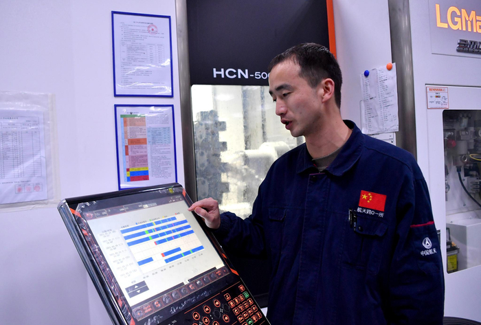 西安航天动力测控技术研究所精密机械加工研究室的车间内，工作人员在介绍卧式加工中心昼夜工作的时间记录（3月18日摄）。新华社记者 刘潇 摄