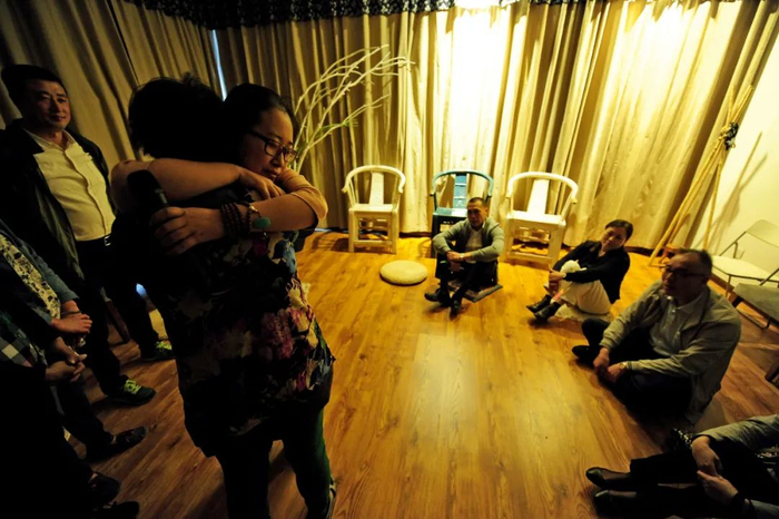 心理顾问通过示范拥抱，让大家增强人与人之间的信任。图/视觉中国