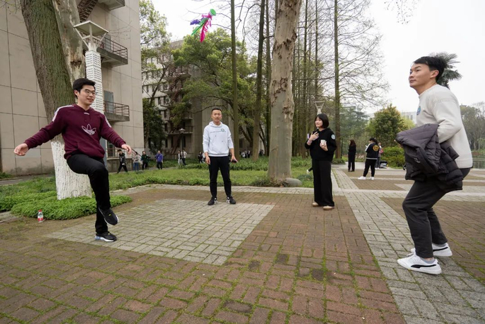 ▲同学们体验踩高跷、踢毽子（刘博文 摄）