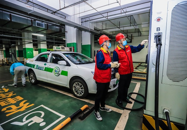 国网乌鲁木齐供电公司党员服务队员在高铁站电动汽车充电站进行用电检查。