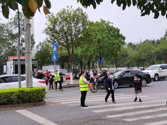 广西钦州市皇庭实验小学“护学岗”的家长志愿者正在执勤（学校供图）
