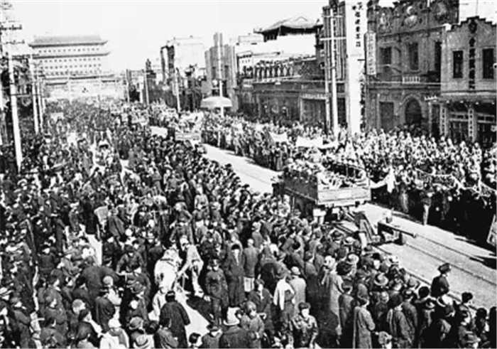北平市民在正阳门大街上夹道欢迎参加入城式的人民解放军。（图片来源：新华社）