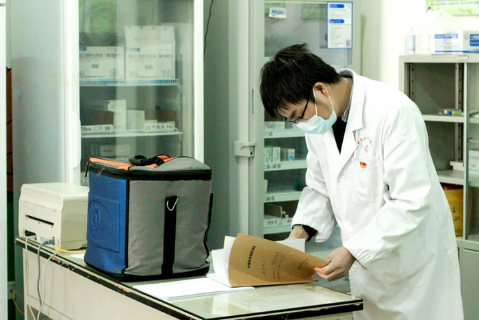 检查接种记录簿是张伟医生每天的工作之一（蔡雯雯 摄）