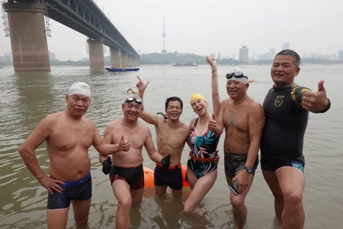 图为2019年11月6日，艾米在中国武汉横渡长江后和当地居民合影。图片由受访者提供