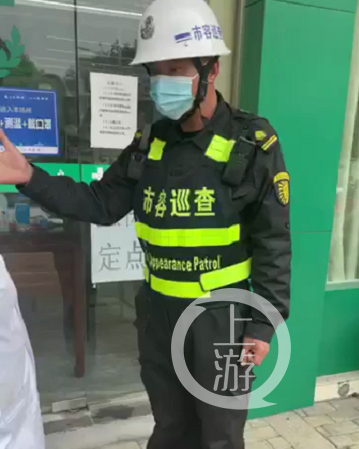 ▲身穿“市容巡查”制服的男子对药店称，不撕垃圾广告就“格杀勿论”。图片来源/视频截图