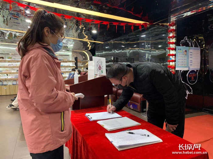 观众在影城入口进行测量体温和扫码登记。长城网记者 许晓星 摄