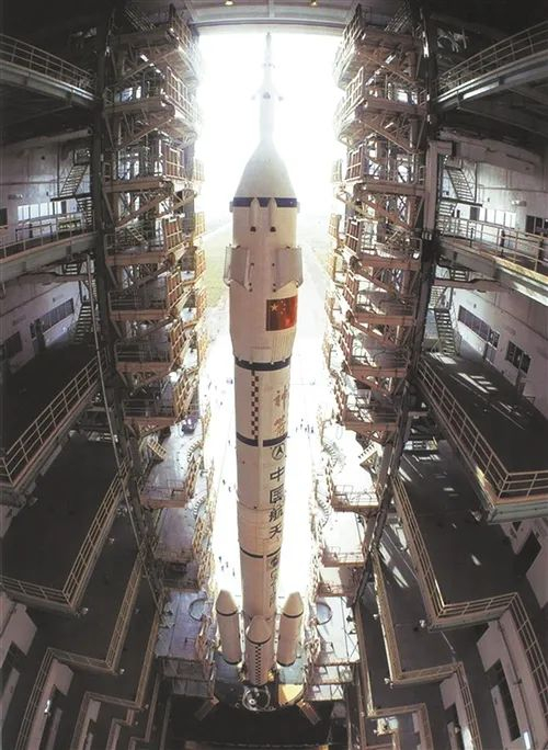 长征-2F火箭载着神舟五号飞船从垂直测试厂房转运至发射塔架。（资料图片） 