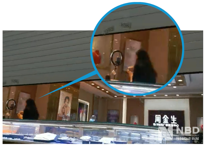 其他商家陆续打烊，“香港周金生”也卷帘门半闭，但店内却做起了直播准备&nbsp;图片来源：每经记者 摄