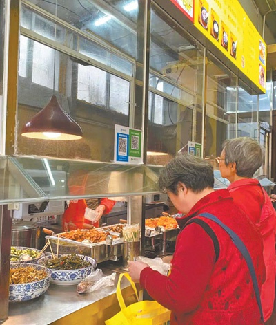 　　在江西南昌市西湖区南站街道铁路二村社区邻里中心的“老铁食堂”，几名老人正在买饭菜。